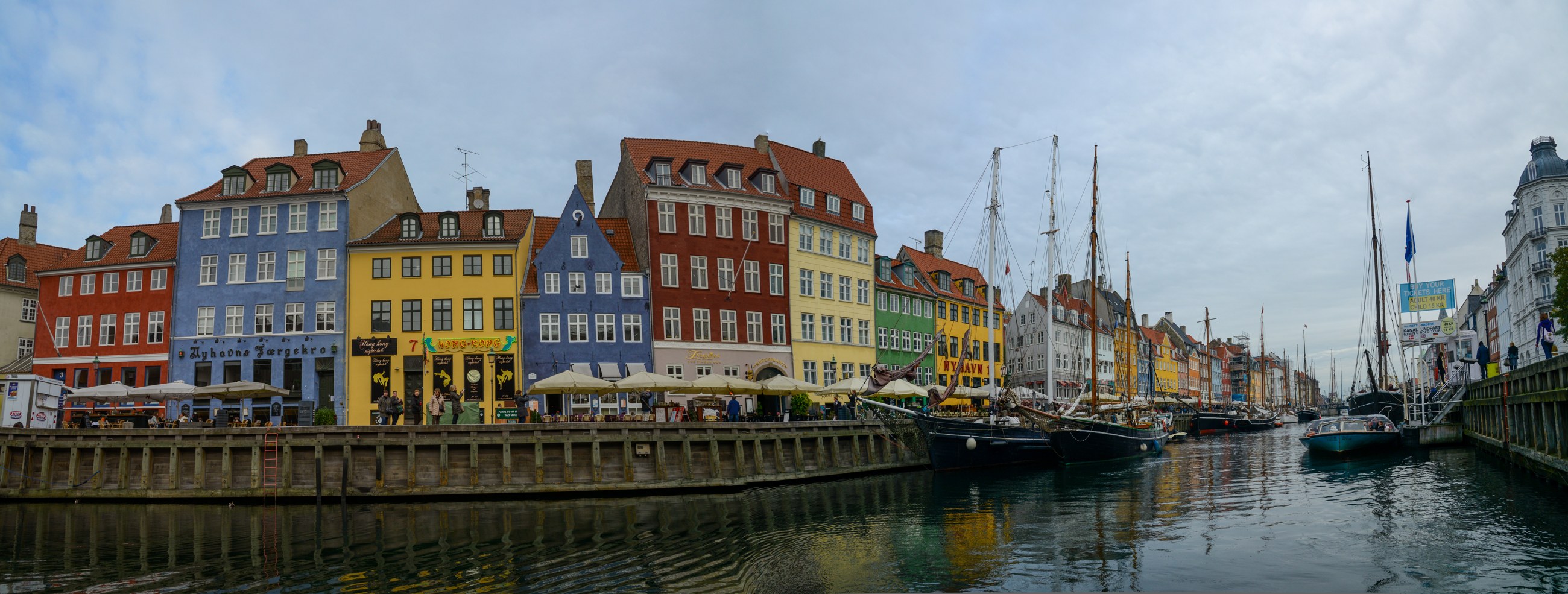 Colourful historic façades and boats along Nyhavn harbour in Copenhagen